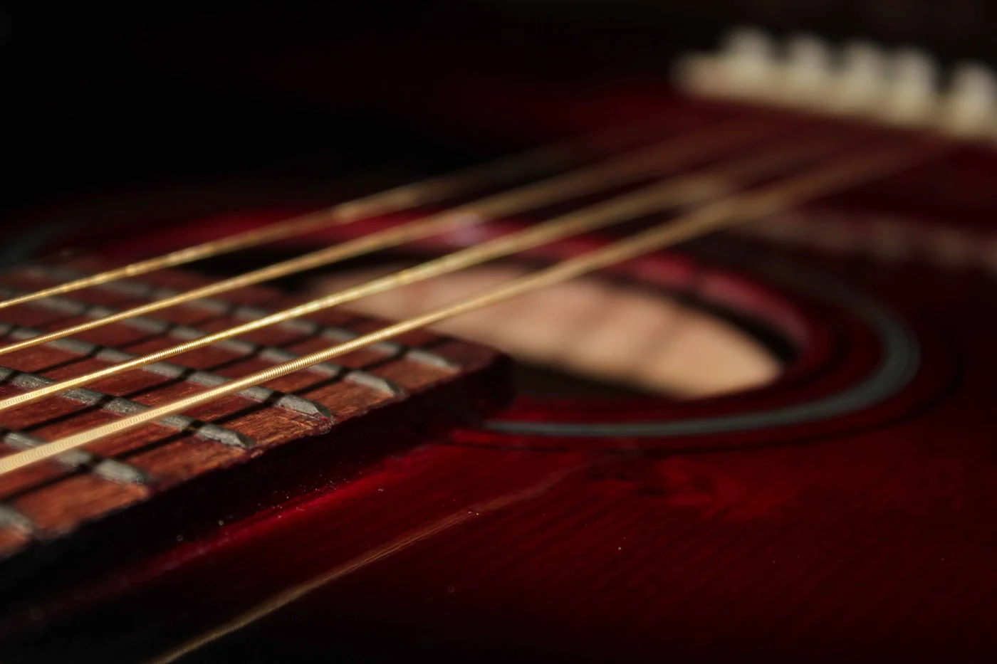 Närbild av strängar och ljudhål på en akustisk gitarr