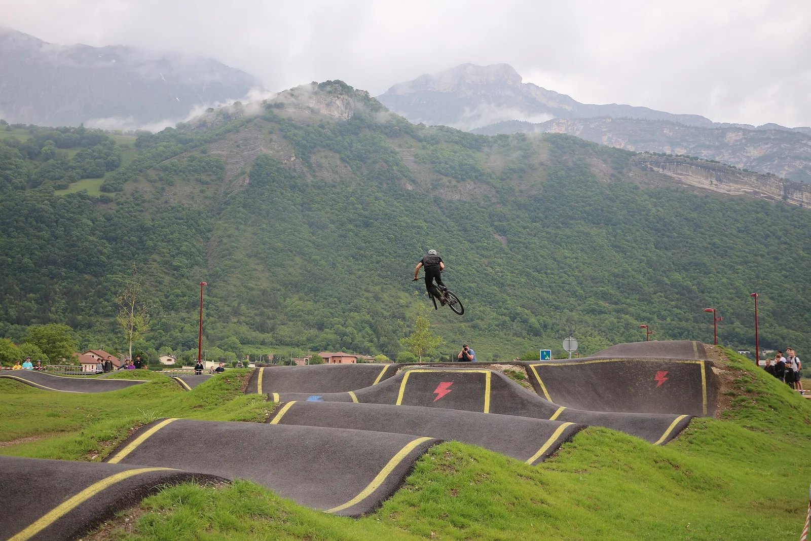 Cyklister på en asfalterad pumptrackbana i Vif i Frankrike, illustrationsbild till banformen
