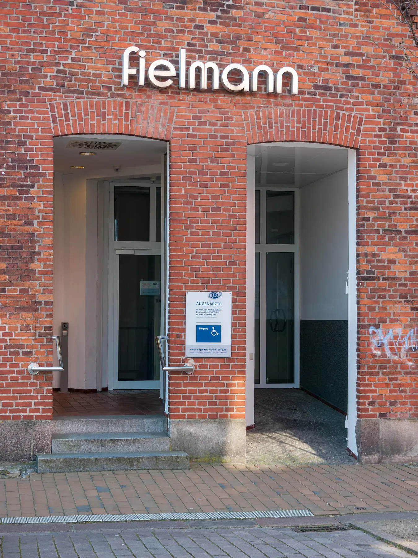 Tegelbyggnad i Rendsburg med trappa i ena valvet och trappfri tillgänglig entré i det andra