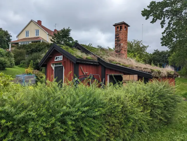 Sagers stuga i Askersund, ett rött trähus med torvtak och hög tegelskorsten