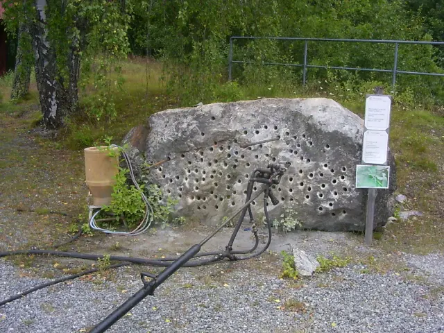 Utomhusutställning vid Zinkgruvans gruvmuseum med borrig utrustning och informationsskylt